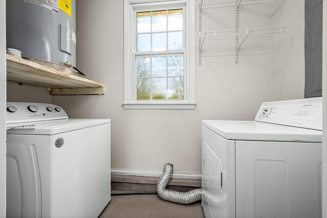 clothes washing area with electric panel, electric water heater, independent washer and dryer, and laundry area