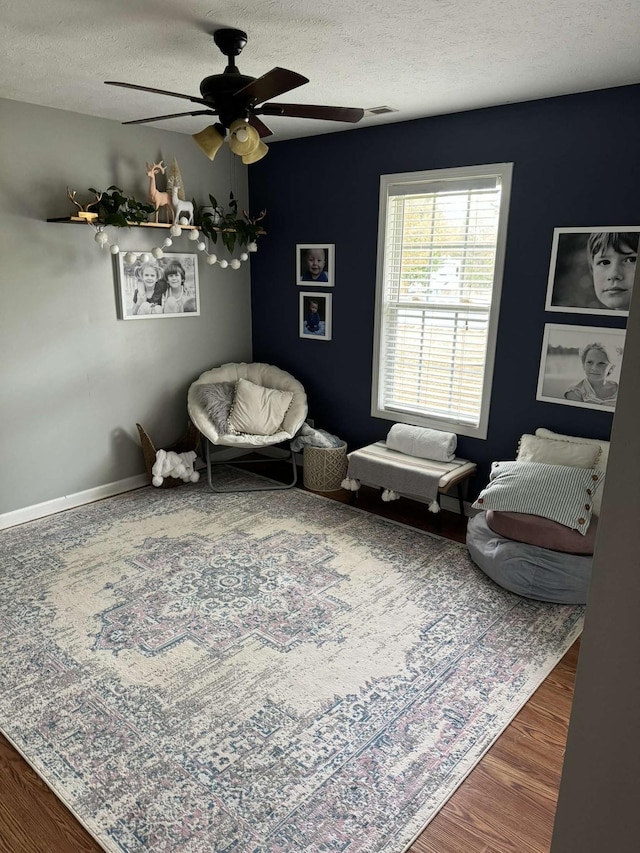 123 Hubbard St, Hohenwald, TN 38462 - sitting room with wood finished floors, visible vents, baseboards, a textured ceiling, and ceiling fan