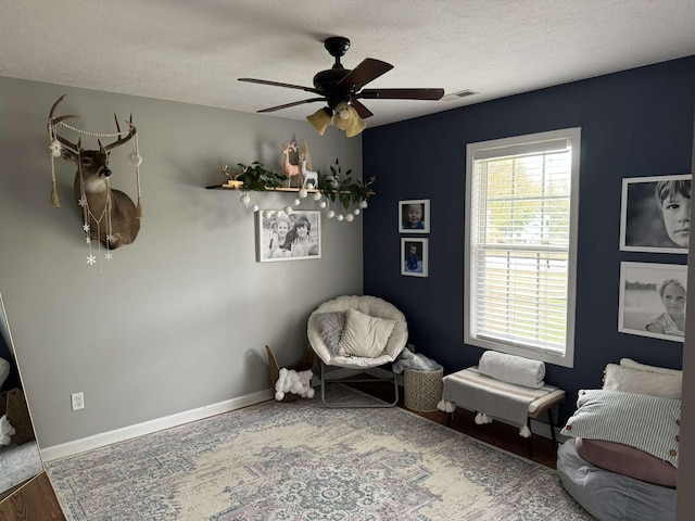 123 Hubbard St, Hohenwald, TN 38462 - living area featuring wood finished floors, a textured ceiling, ceiling fan, baseboards, and visible vents