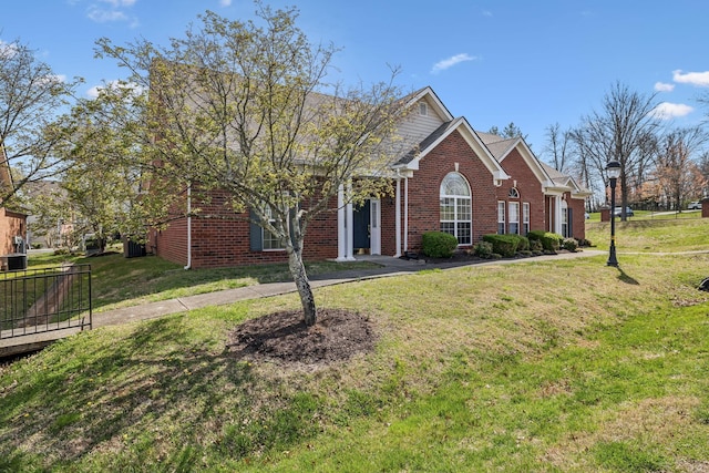 view of front of house with a front lawn and brick siding