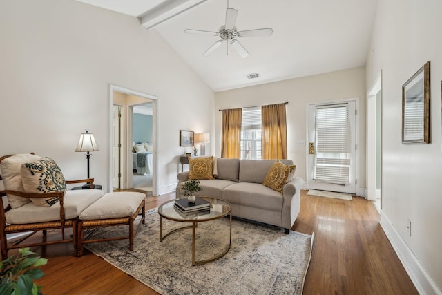 living room with beam ceiling, a ceiling fan, wood finished floors, baseboards, and visible vents