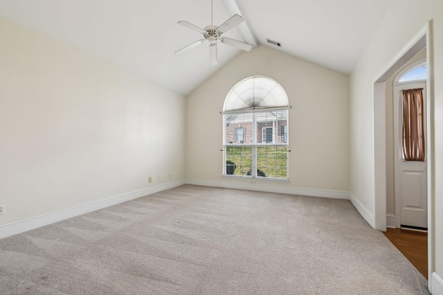 carpeted empty room featuring baseboards, visible vents, lofted ceiling with beams, and a ceiling fan