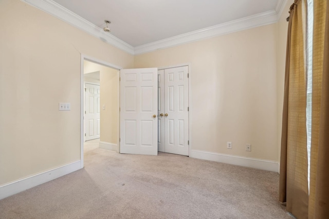 unfurnished bedroom featuring light carpet, baseboards, a closet, and crown molding