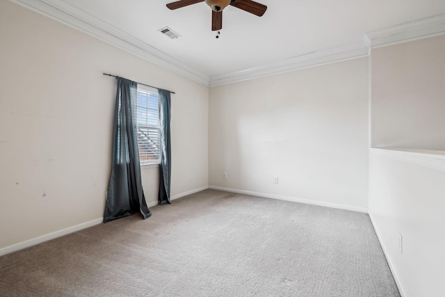 carpeted empty room featuring baseboards, ornamental molding, visible vents, and ceiling fan