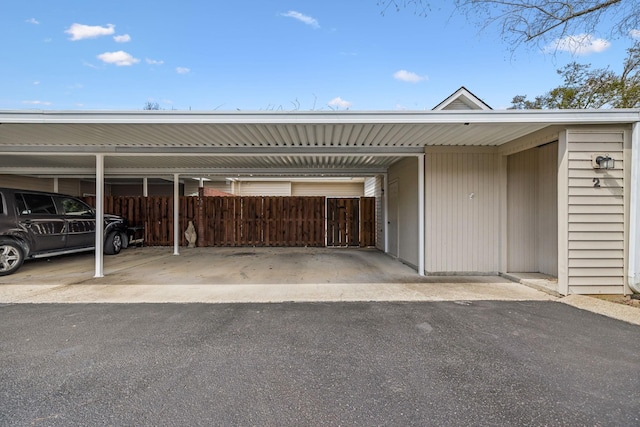 garage with fence and covered parking