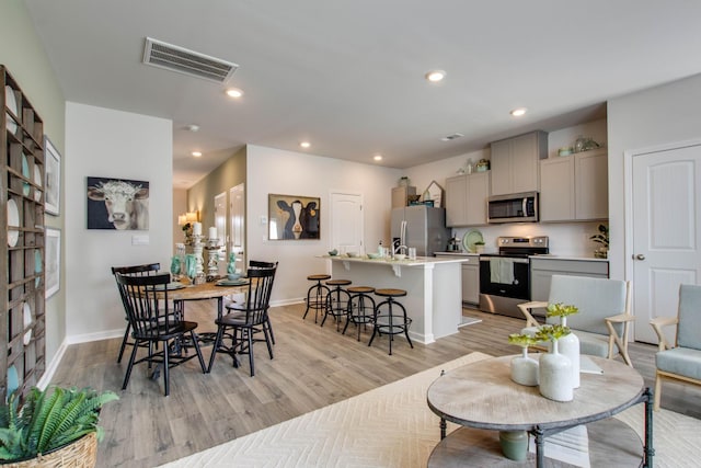 dining room featuring baseboards, light wood finished floors, visible vents, and recessed lighting