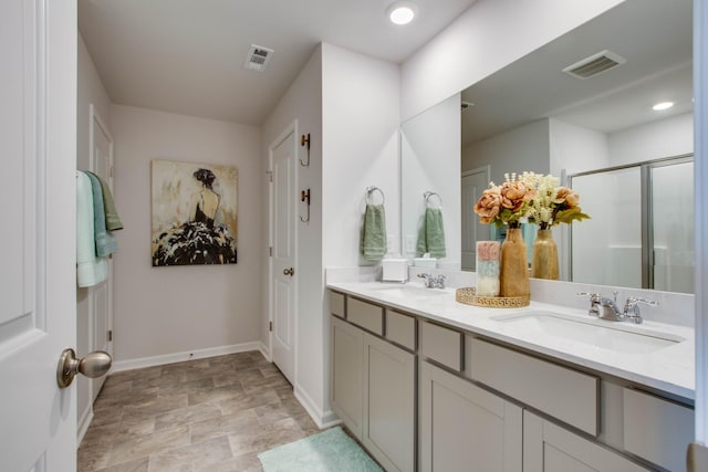 full bath featuring a shower stall, visible vents, baseboards, and a sink