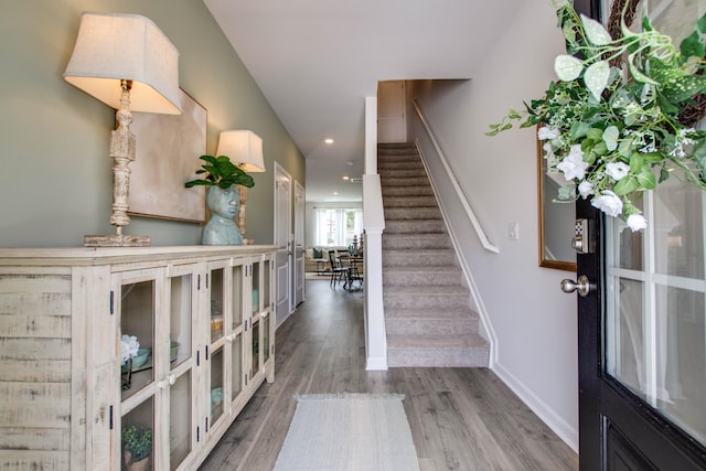 entryway with recessed lighting, wood finished floors, baseboards, and stairs