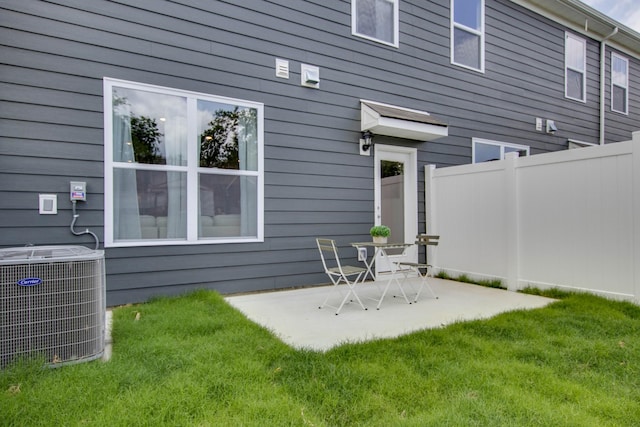 back of house with a lawn, central AC, a patio, and fence