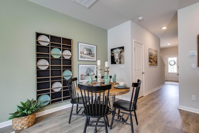 dining space featuring baseboards, wood finished floors, visible vents, and recessed lighting