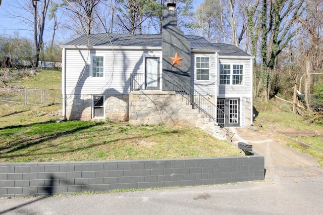 view of front of home with a chimney, a front lawn, and fence