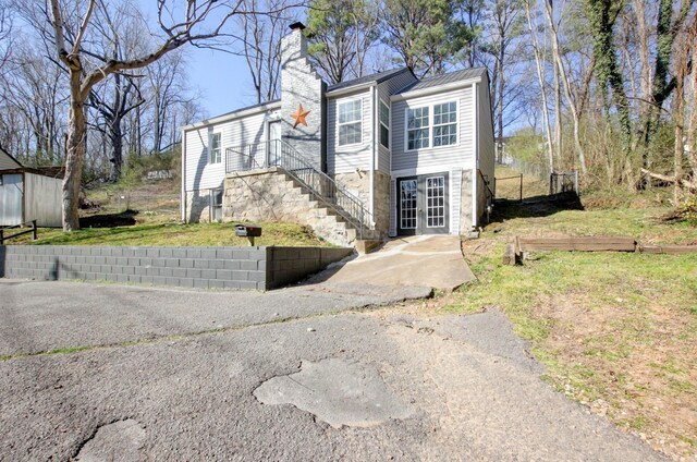exterior space featuring stairs, french doors, and a chimney