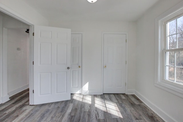 unfurnished bedroom with baseboards and wood finished floors
