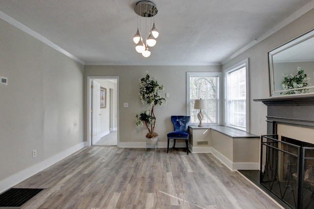 unfurnished room with visible vents, ornamental molding, wood finished floors, baseboards, and a chandelier