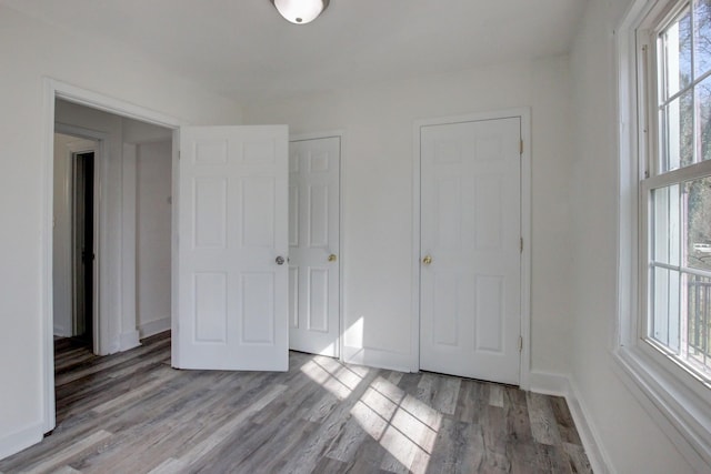 unfurnished bedroom with baseboards and light wood finished floors