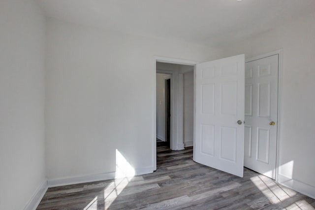 unfurnished bedroom with wood finished floors and baseboards