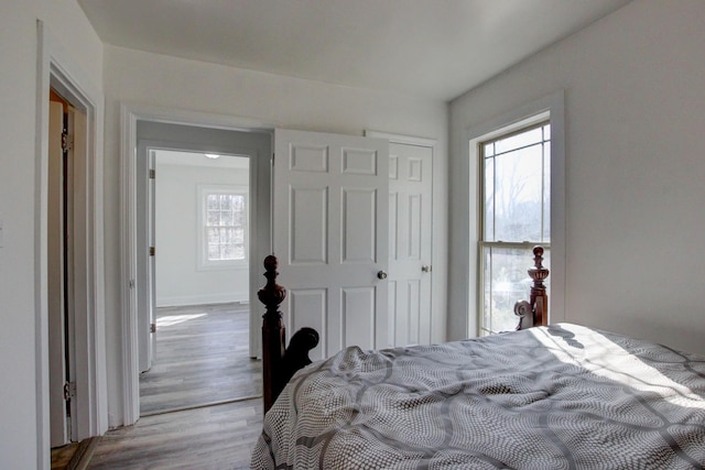 bedroom featuring a closet, baseboards, and wood finished floors