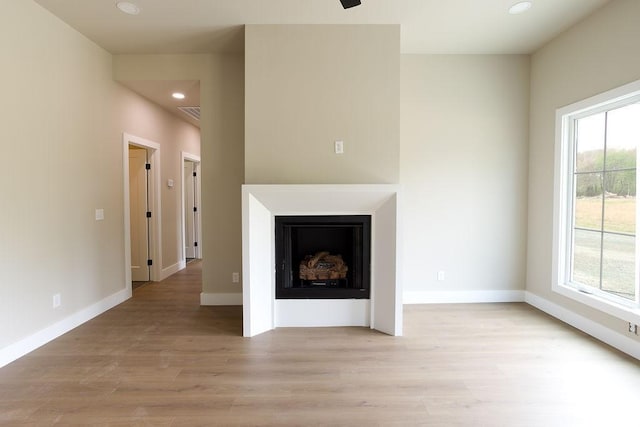 unfurnished living room with plenty of natural light, recessed lighting, and light wood-style flooring