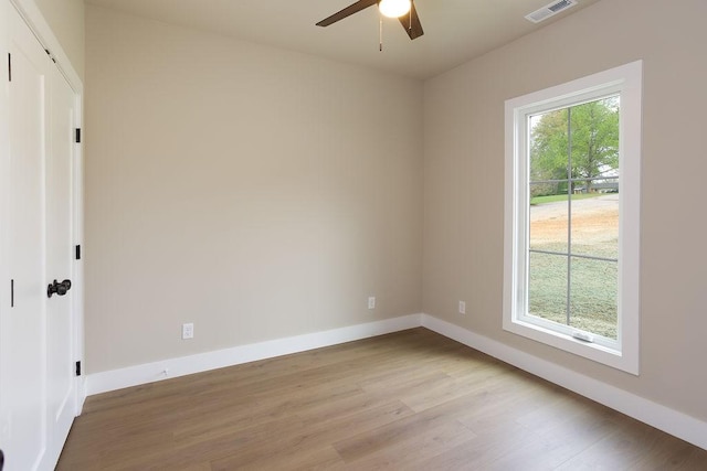 unfurnished room with ceiling fan, visible vents, baseboards, and light wood finished floors