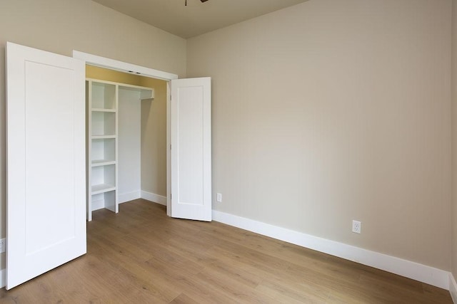 unfurnished bedroom with baseboards and wood finished floors