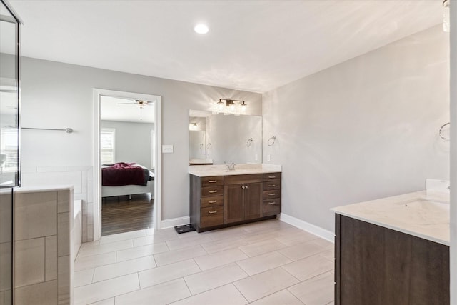 bathroom with baseboards, vanity, ensuite bath, and a ceiling fan