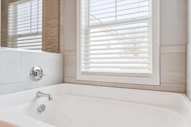 full bath with a garden tub and a healthy amount of sunlight