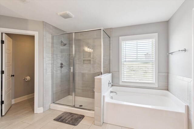 bathroom with tile patterned floors, baseboards, a bath, and a shower stall