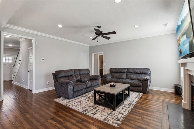 living area featuring wood finished floors, baseboards, visible vents, a fireplace with flush hearth, and ceiling fan
