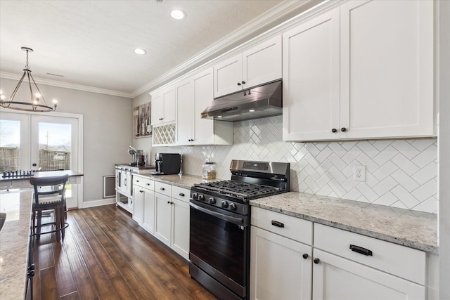kitchen with under cabinet range hood, gas stove, white cabinets, crown molding, and a chandelier
