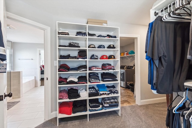 spacious closet with tile patterned floors, independent washer and dryer, and carpet floors