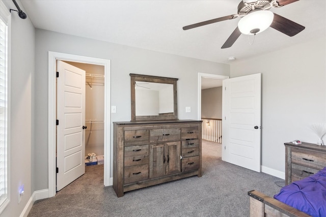 carpeted bedroom with baseboards, ceiling fan, and a spacious closet