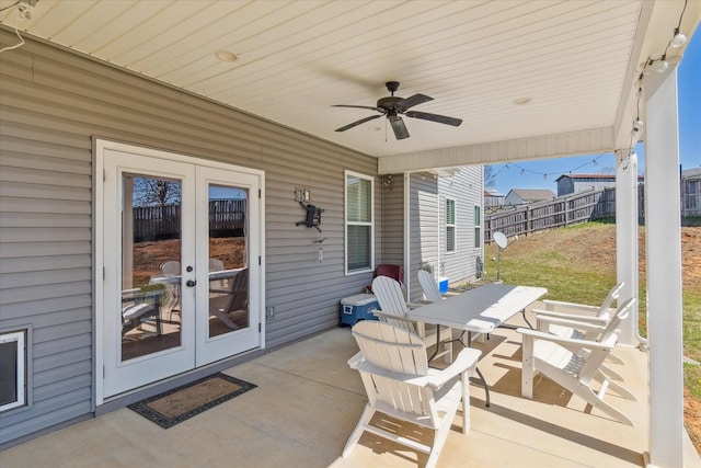 view of patio featuring french doors, outdoor dining area, a ceiling fan, and fence