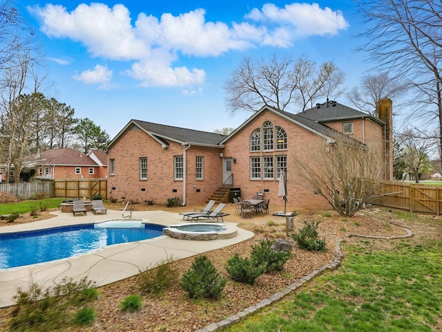 rear view of house with a patio, a fenced backyard, brick siding, entry steps, and a pool with connected hot tub