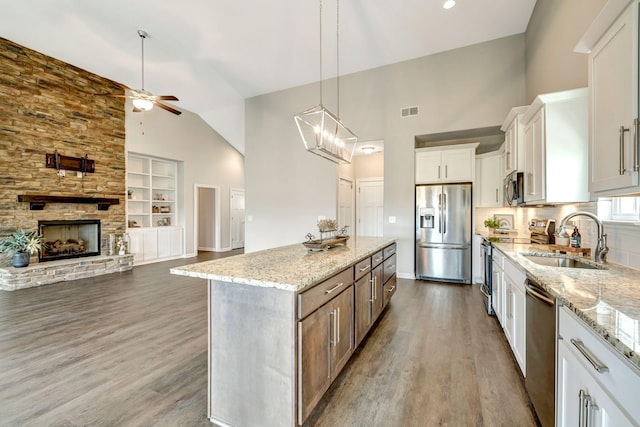 kitchen featuring ceiling fan with notable chandelier, dark wood finished floors, a sink, visible vents, and appliances with stainless steel finishes