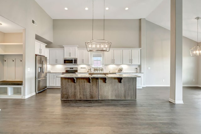 kitchen with backsplash, appliances with stainless steel finishes, visible vents, white cabinets, and an inviting chandelier