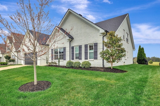 view of front of home with brick siding, a garage, a front lawn, and concrete driveway