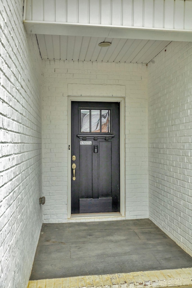 entrance to property featuring brick siding