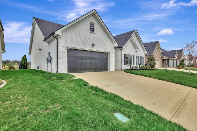 view of front facade featuring a front lawn, driveway, brick siding, and roof with shingles