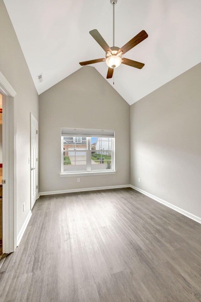 unfurnished room featuring baseboards, visible vents, wood finished floors, and ceiling fan