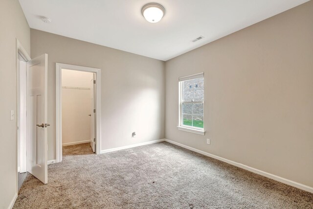 spare room with baseboards, carpet flooring, and visible vents