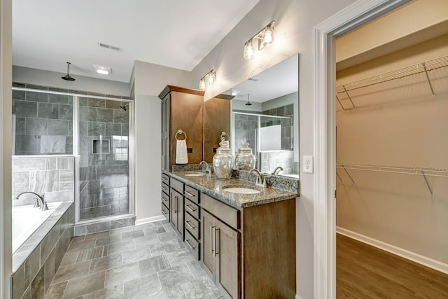 full bathroom with a shower stall, a sink, and a garden tub