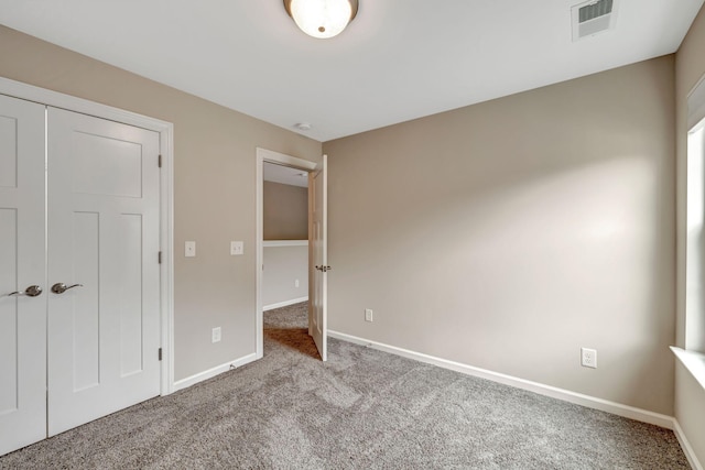 unfurnished bedroom with carpet floors, baseboards, and visible vents