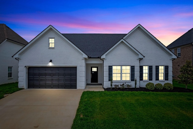 traditional-style house with an attached garage, brick siding, concrete driveway, and a front yard