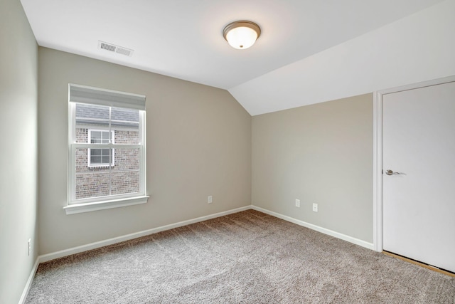 additional living space with baseboards, visible vents, lofted ceiling, and carpet