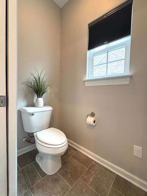 bathroom featuring toilet, tile patterned flooring, and baseboards