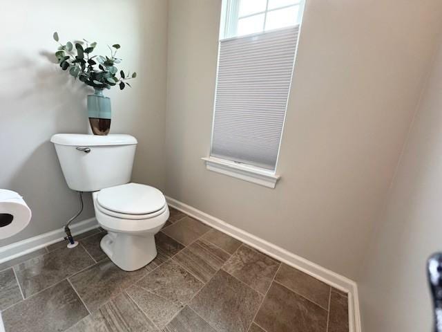 bathroom with baseboards and toilet