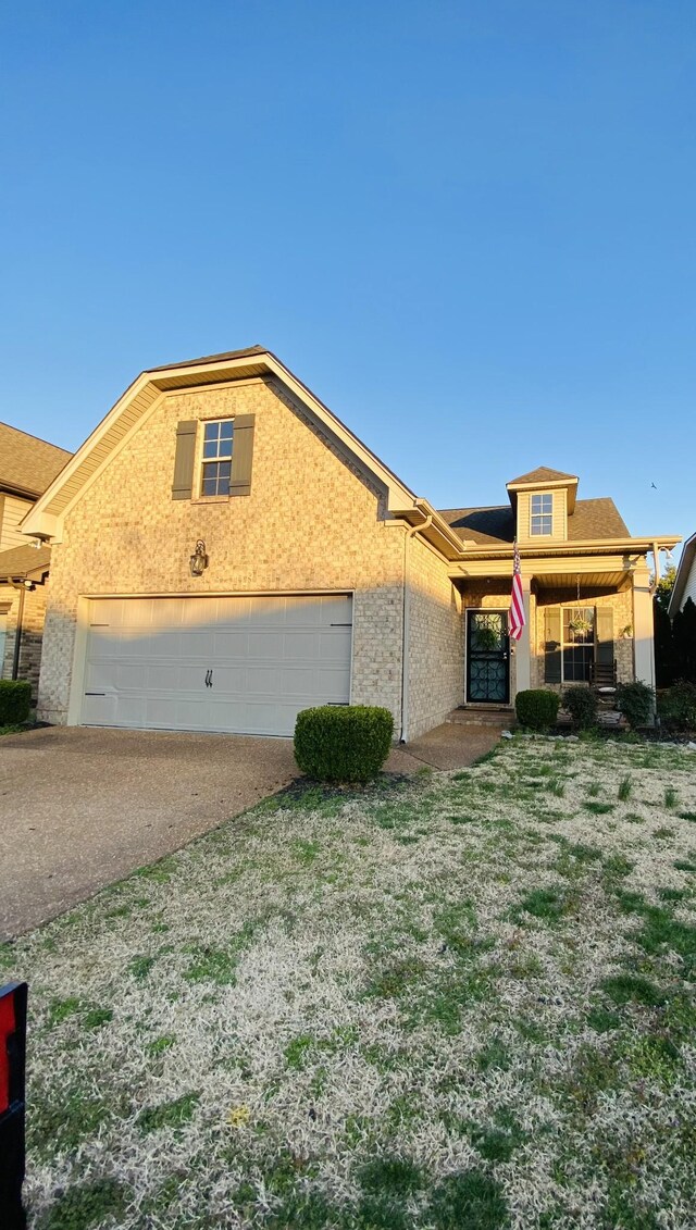 view of front of property featuring a garage, brick siding, and driveway