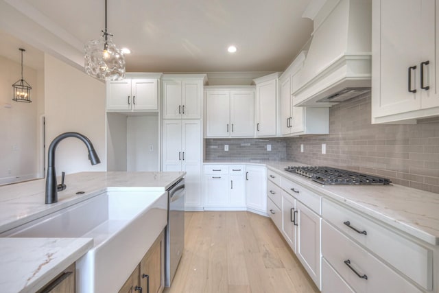 1251 Payton Ln, Gallatin, TN 37066 - kitchen with premium range hood, appliances with stainless steel finishes, a sink, light wood finished floors, and white cabinetry