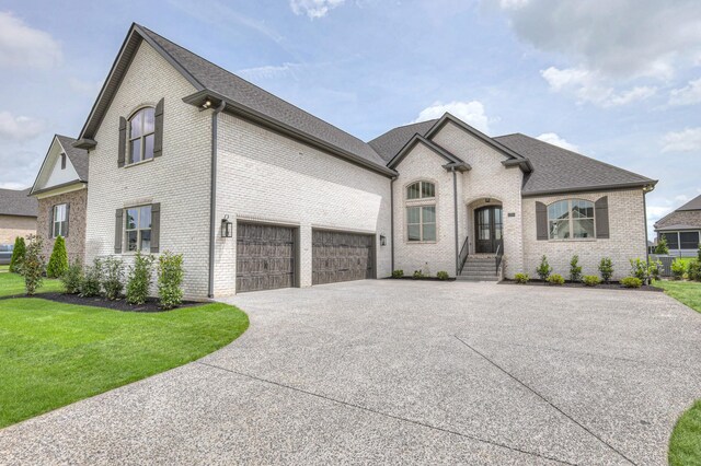 1251 Payton Ln, Gallatin, TN 37066 - french country inspired facade featuring driveway, brick siding, a front yard, a garage, and a shingled roof