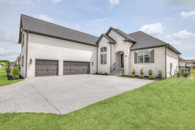 1251 Payton Ln, Gallatin, TN 37066 - french country home featuring driveway, brick siding, an attached garage, a front lawn, and roof with shingles